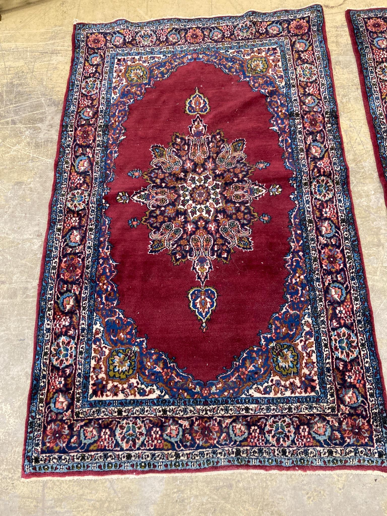 A pair of North West Persian burgundy ground rugs, 160 x 98cm